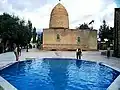 A swimming pool in the foreground of the mausoleum