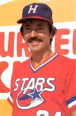 A man in a red baseball jersey and navy blue cap