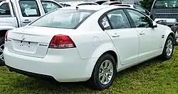 Rear-three-quarters view of a white-coloured sedan