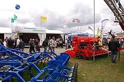 A red and a blue machine in front of a booth with a sign on the booth