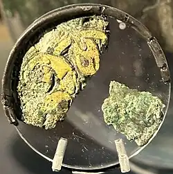 Color photograph of an escutcheon from the Benty Grange hanging bowl