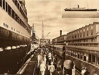 Passenger train on pier with cruise ship