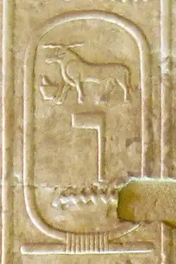 On a yellowish stone, cartouche inscribed with the hieroglyphs of a ram, above a flag-pole-like symbol and a wave of water