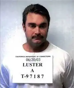 Mug shot of Luster on a white background, with a sign on his chest