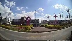 alt:A park with the sculpture of a symbol of Venus surrounded by several crosses.