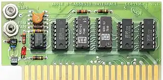 A green circuit board with six chips in a row. There are two phone jacks in the top-left corner. A gold edge connector runs along the bottom of the board.