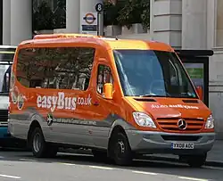 Orange and grey Mercedes-Benz minibus with 'easyBus.co.uk' signwriting on front and side