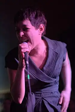 close-up of Béatrice Bonifassi appearing to sing or scream into a microphone