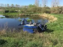 This amphibious boat 'amphi king' is used for maintaining waterways, like freeing them from water plants