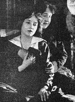 Black and white film still showing an older woman hugging a younger woman