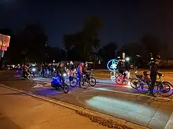 Cyclists gathering on a road during night.