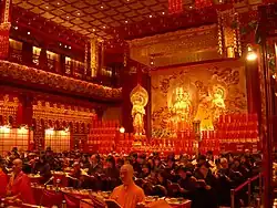 Inside of the Hundred Dragon Hall, showing a seated Buddha Maitreya flanked by two Bodhisattvas