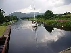 A sailing boat on the Caledonian Canal approaches from the Loch Linnhe side of the Mallaig Extension Railway swing bridge.