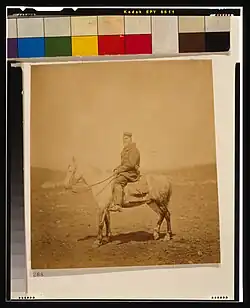 An 1855 photo of Captain Chawner, a British Crimean War official, seated on a horse. Around the photo are colour blocks, and It is a library of congress scan.
