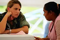 A nurse listens to a young woman