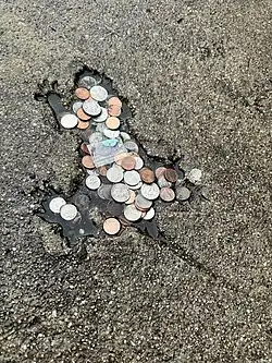 The hole on January 13, filled with coins and a bag of estradiol pills