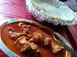 A chicken curry from Maharashtra, India with rice flour chapatis. The dish is popular worldwide.[42]