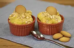 Two servings of banana pudding, each served in a red ramekin