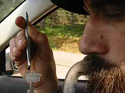 A man inhaling cannabis concentrate vapor from a dab rig