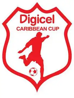 A red and white logo of a shield containing an interpretation of a player kicking a ball.