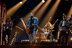 The band on stage with spotlights