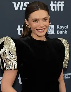 A photograph of Olsen smiling at the camera