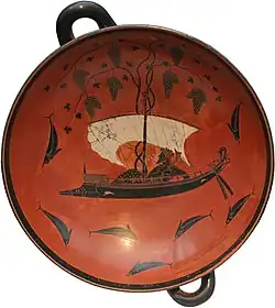 A Greek wine-cup, with two handles: in the centre of the bowl, Dionysus sits on a ship, surrounded by dolphins in the sea