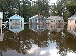 A flooded area, with houses in the background