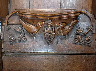 Misericord with a carved scene showing a fox preaching from a pulpit to a cockerel and a goose.