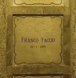 A marble gravestone on the wall of a crypt