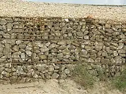 Gabion, welded wiremesh filled with stone.