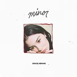 A picture of a young woman framed by a red border placed on a white background. In the center top, it reads the title: "Minor". In the center bottom, it reads the artist name: "Gracie Abrams".