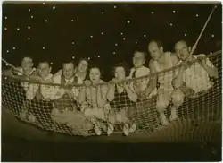Many performers laying on a net