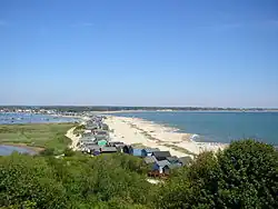 view looking down from a hill onto a sandy shoreline