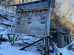 Image of white sign in snow. Text on sign says safety board.