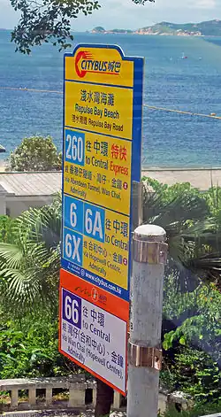A sign, seen through a vehicle, with large numbers and text in Chinese and English. The upper portion is yellow; a small section at the bottom is in orange