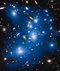 Abell 2744 intracluster light artificially colored in blue. This light come from galaxies that were torn apart long ago by the cluster's gravitational forces. [12]