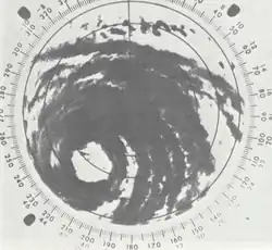 Black and white radar image of a tropical cyclone; gray areas denote areas where rainfall is occurring. Although only a portion of the tropical cyclone is visible, rainbands and a central eye feature can be clearly made out.