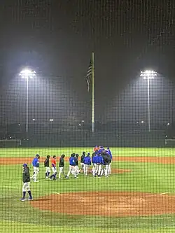 Huskies baseball celebrating their victory after the program's first night home game.