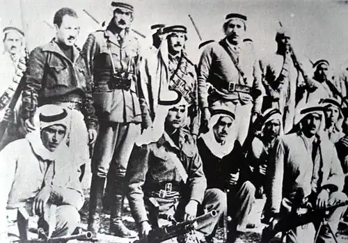 Abd al-Qadir al-Husayni returned to Palestine after an exile of ten years, and began organizing Arab resistance to forcible partition of the country. He is seen here (standing center) with aides and Palestinian irregulars, Jerusalem district, February 1948