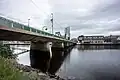 a view from below of a road bridge with green railings