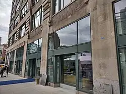 A greyish building with large glass doors.