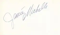 The handwritten name "Janée Michelle" in grey slanted from the bottom left to the top right all on a white background with the "M" curled under the first name