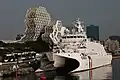 Anping-class offshore patrol vessel of the Coast Guard Administration in front of the Kaohsiung Music Center