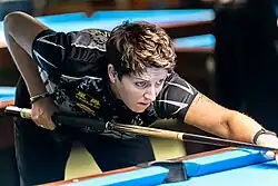 A woman playing pool