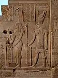 Seshat shown holding the mallet, pole, and rope used in the "stretching the cord" ritual, alongside Horus. Bas-relief at the Temple of Kom Ombo (c. 180–47 BC), Ptolemaic dynasty.