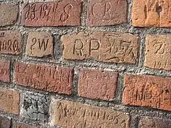 Inscriptions carved by local figures through the ages, on the wall of St. Bartholomew's Church