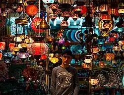 Teenager in the door of a lantern shop.