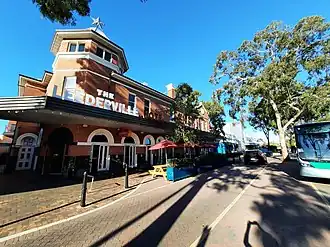 Red brick building next to road with trees