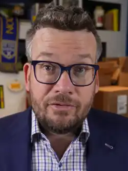 John Green in a vlog, smiling to camera